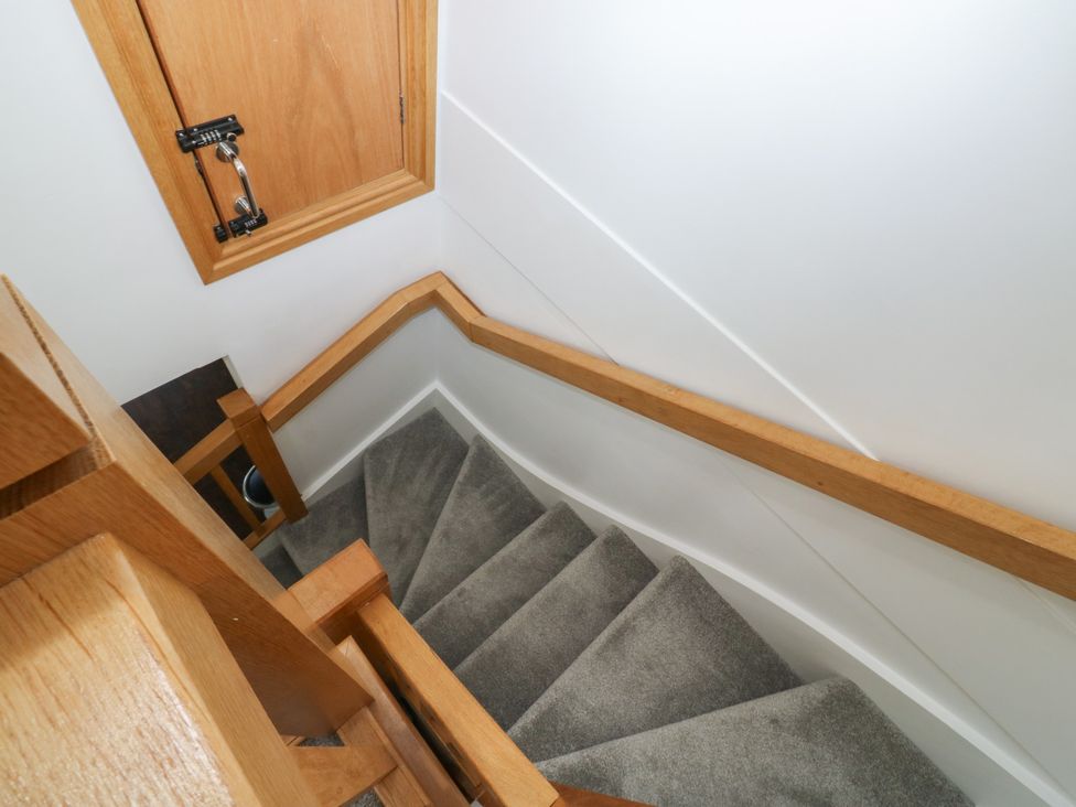 A staircase with wooden handrail and wall at 2 Court Cottage, Dartmouth