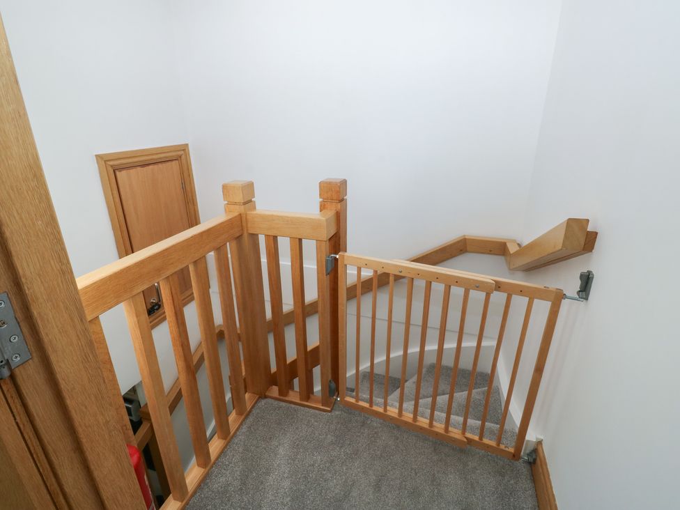 A stairwell with a wooden gate and carpet at 2 Court Cottage Dartmouth