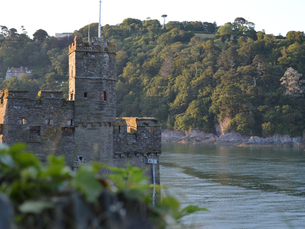 A castle by the water surrounded by trees at 2 Court Cottage, Hillfield Village Dartmouth