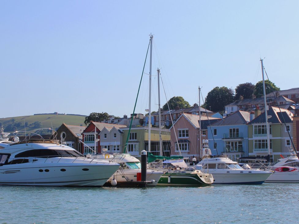 A marina with boats and colorful houses at 2 Court Cottage, Hillfield Village Dartmouth
