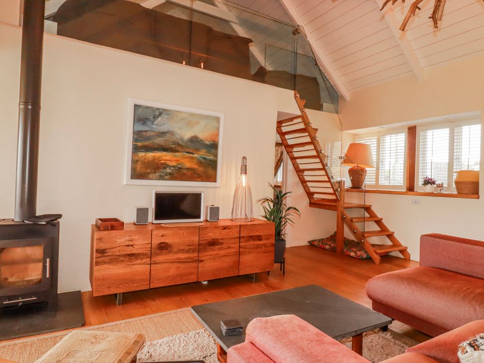 A living room with a wood stove and television at Roughtor Barn Poldue near Camelford