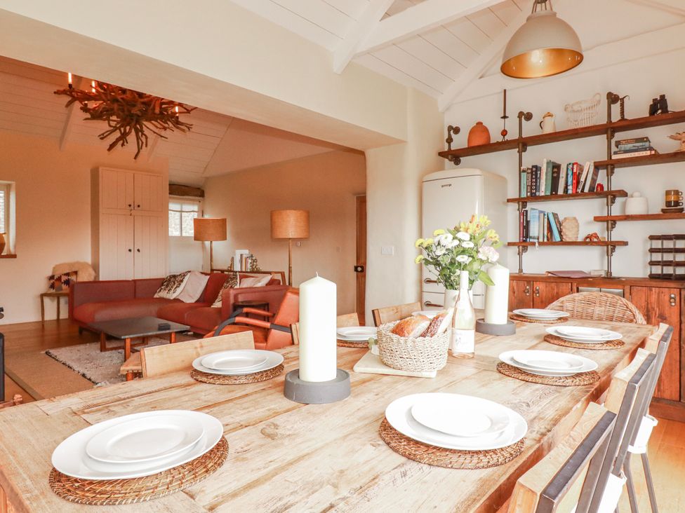 A dining room with a wooden table and chairs at Roughtor Barn Poldue near Camelford