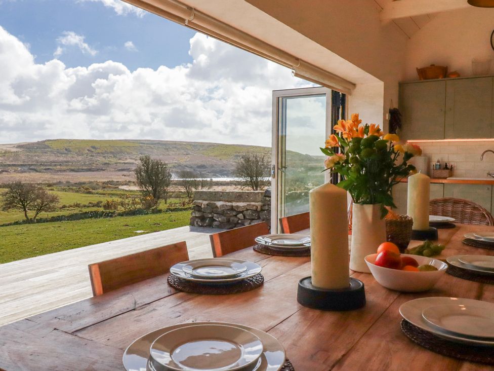A dining room with a table set for a meal at Roughtor Barn Poldue near Camelford