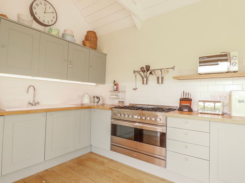 A kitchen with cabinets and stove at Roughtor Barn Poldue near Camelford