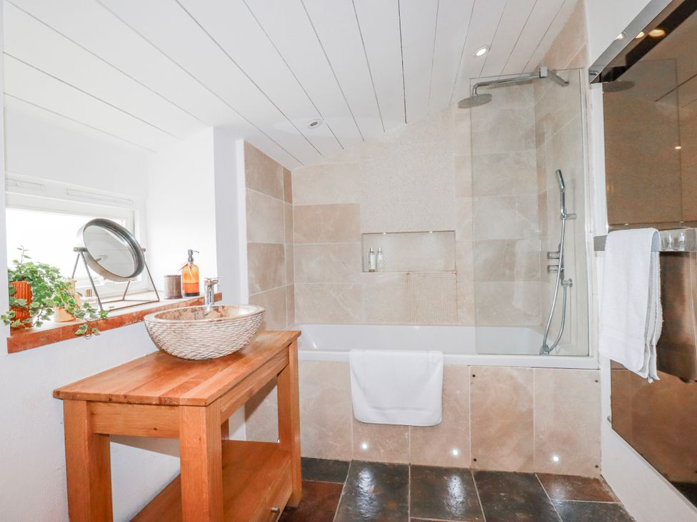 A bathroom with a bathtub and sink at Roughtor Barn Poldue near Camelford