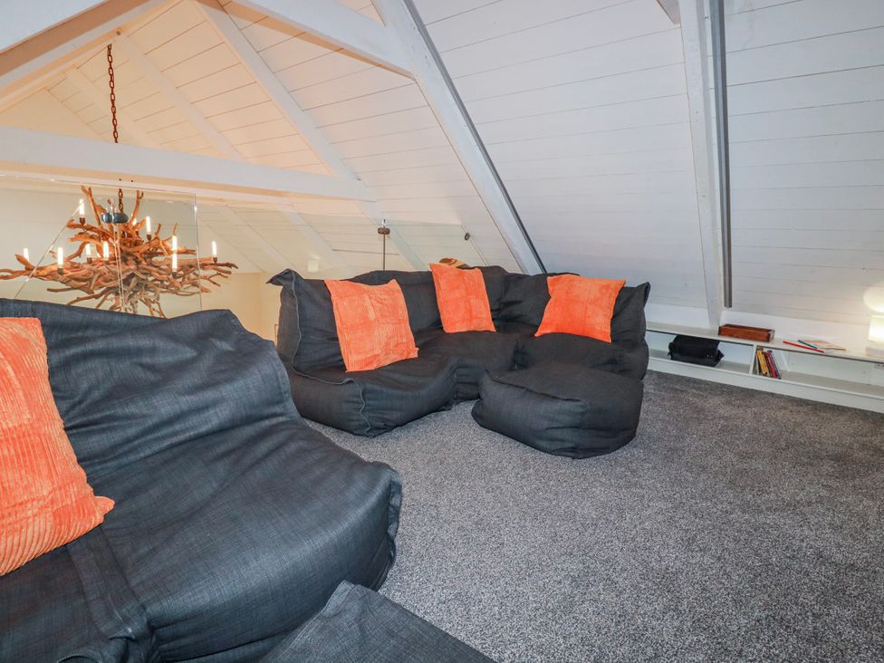 A living room with a sofa and chandelier at Roughtor Barn near Poldue Camelford