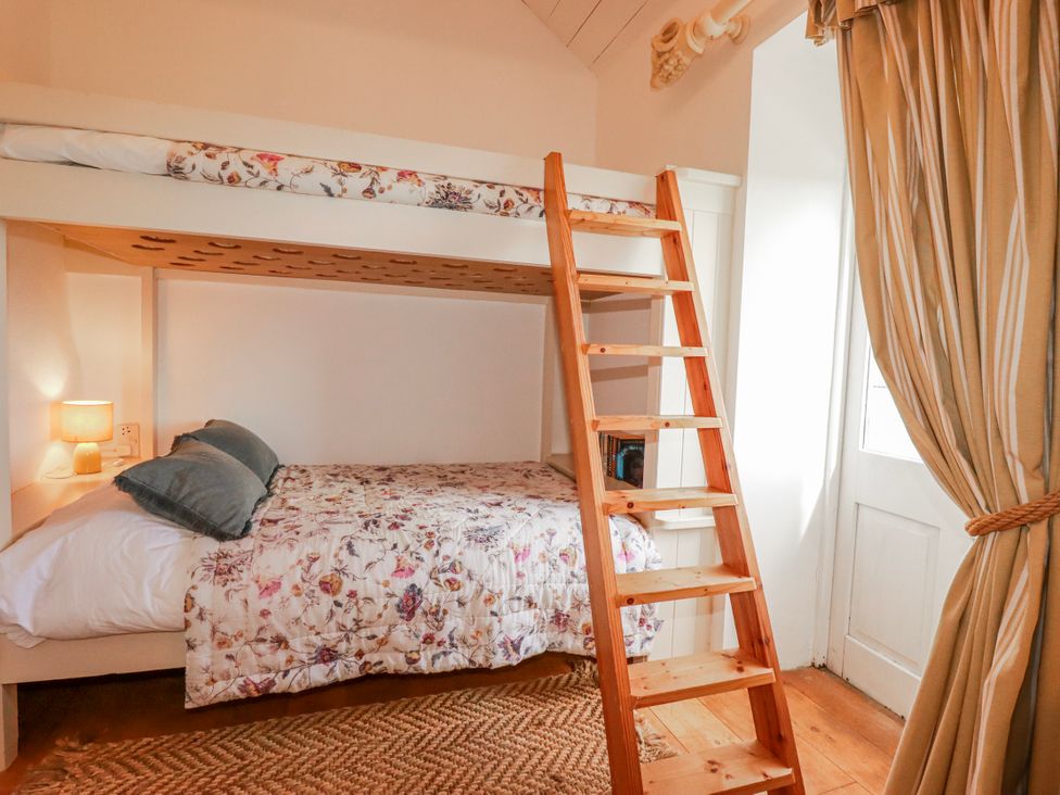 A bedroom with a bunk bed and a wooden ladder at Roughtor Barn Poldue near Camelford