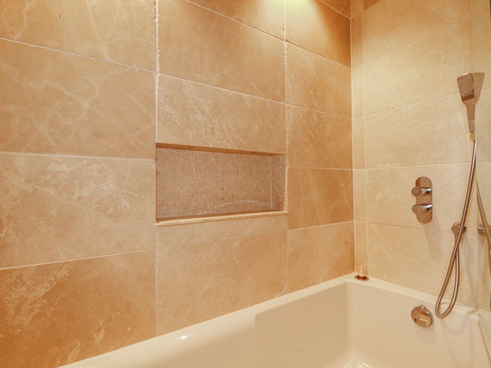 A bathtub and shower setup in a bathroom at Roughtor Barn Poldue near Camelford
