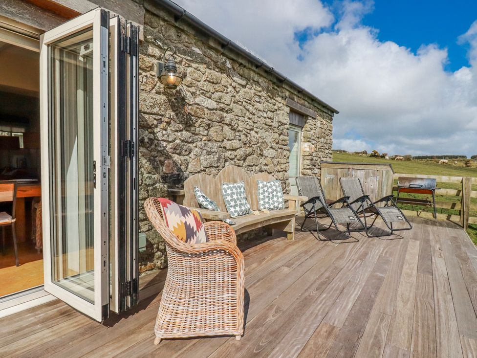 An outdoor area with seating on a wooden deck at Roughtor Barn Poldue near Camelford