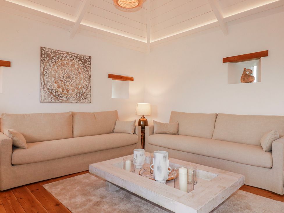 A living room with sofas and a coffee table at Logan Barn in Poldue near Camelford