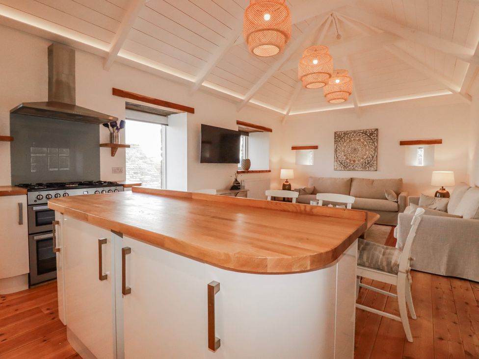 A kitchen with an island and stove at Logan Barn in Poldue near Camelford
