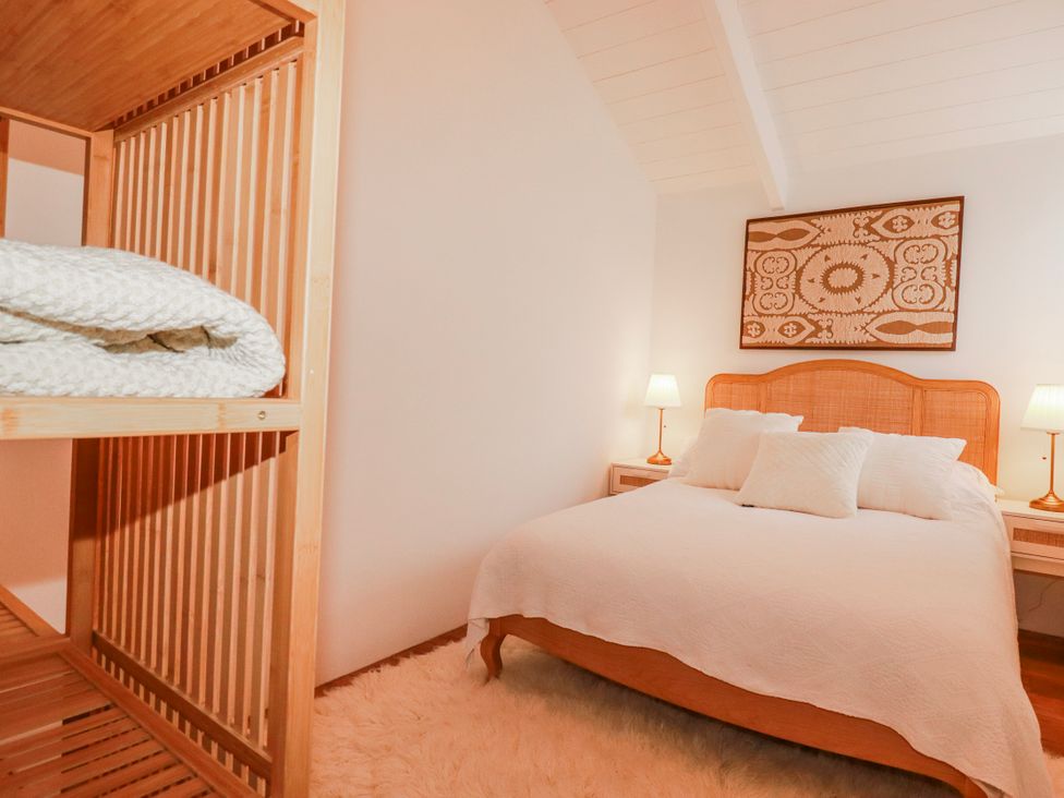 A bedroom with a bed and shelf at Logan Barn in Poldue near Camelford