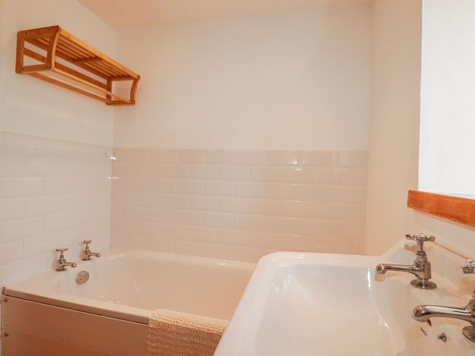 A bathroom with a bathtub and sink at Logan Barn in Poldue near Camelford
