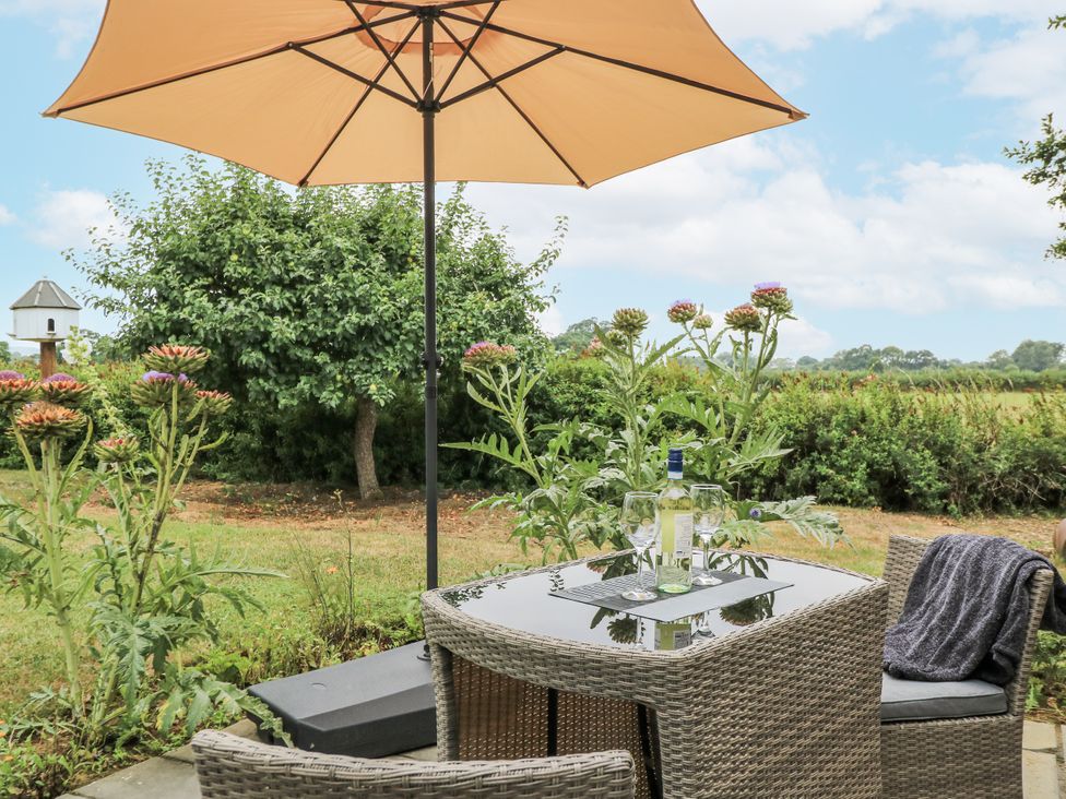 An outdoor seating area with a table and chairs at The West Wing in Potterne