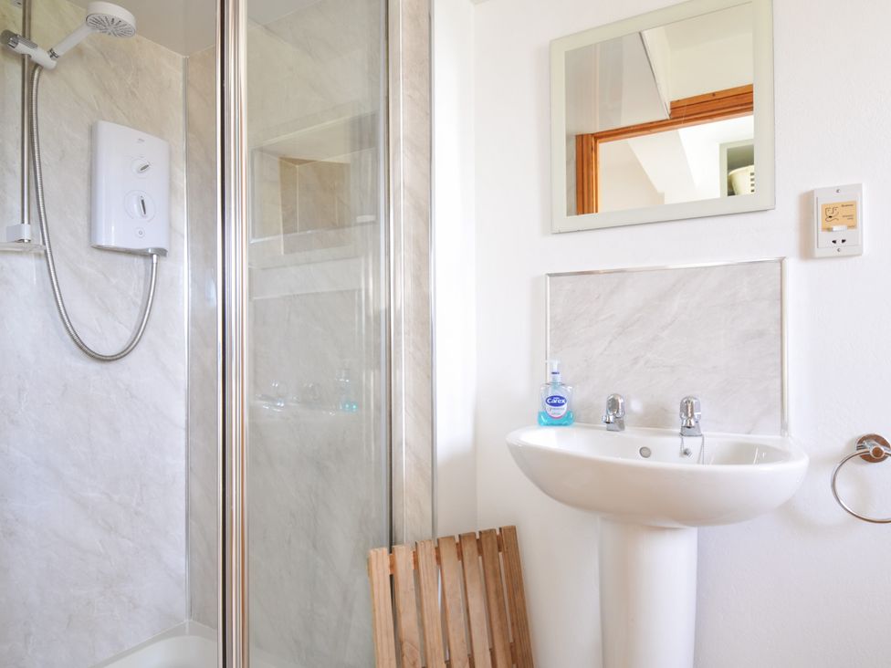 A bathroom with a shower and sink at Seaworthy in Daymer Bay