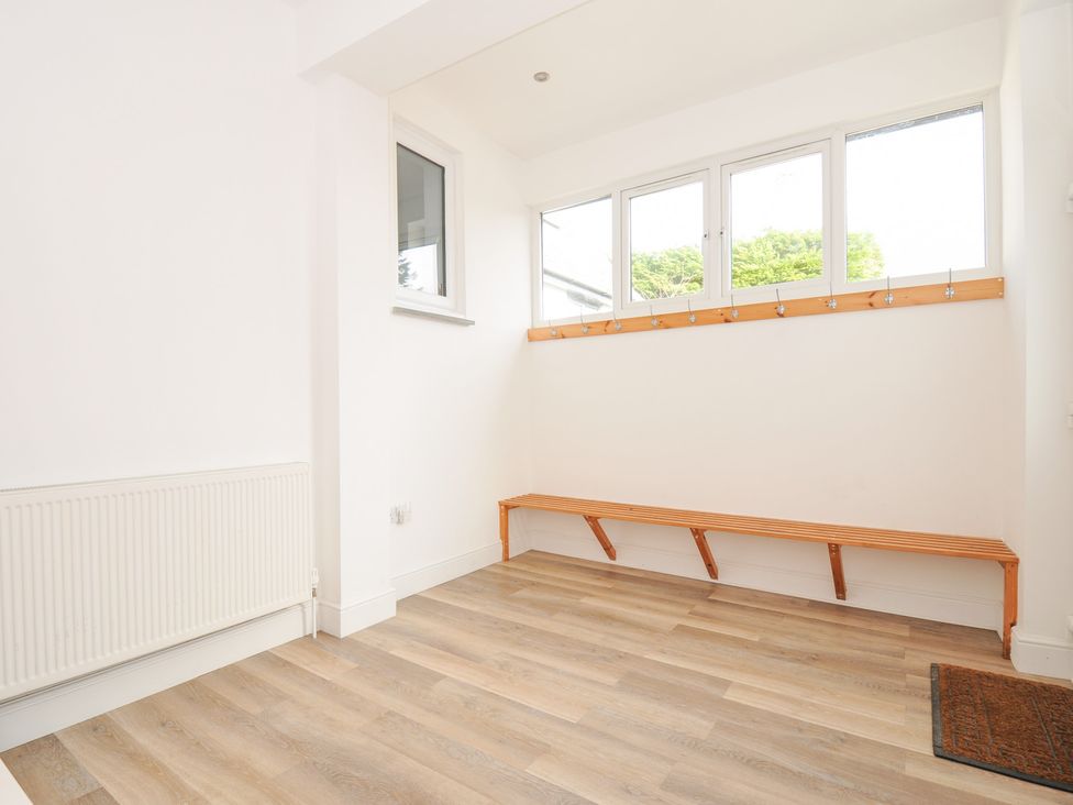 A mudroom with a bench and hooks at Seaworthy in Daymer Bay