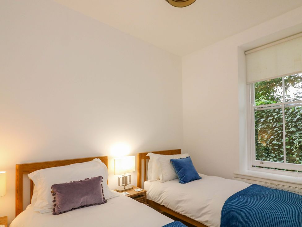 A bedroom with two single beds and a window at 2 The Old School House