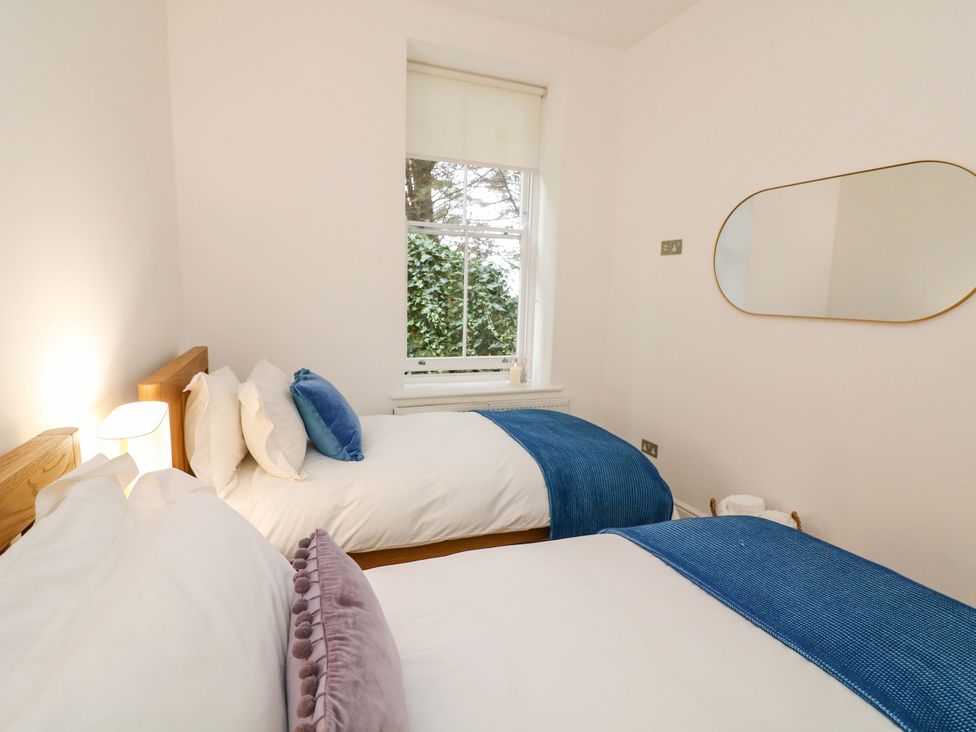 A bedroom with two beds and a window at 2 The Old School House