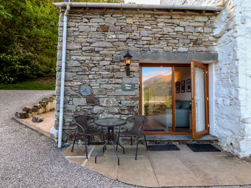 An outdoor area with a table and chairs at Wren's Nest Thornthwaite near Braithwaite