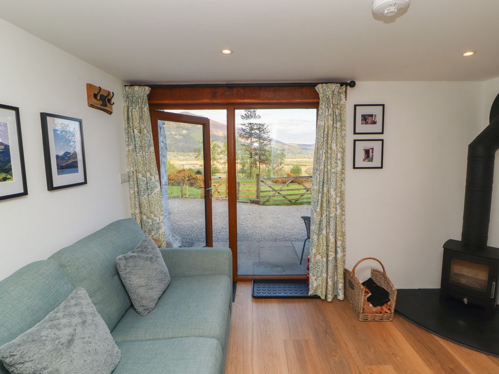 A living room with a sofa and fireplace at Wren's Nest in Thornthwaite near Braithwaite