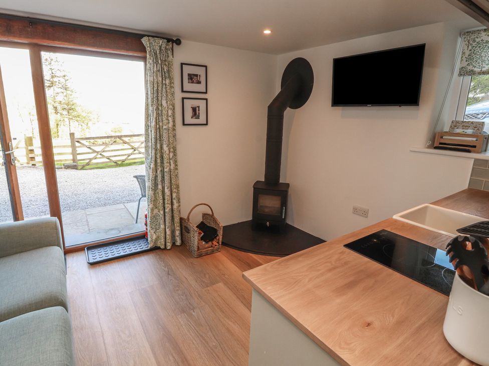 A living room with a sofa and television at Wren's Nest in Thornthwaite near Braithwaite