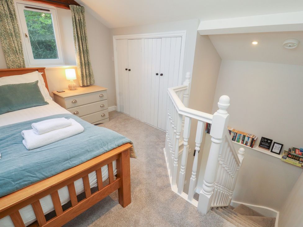 A bedroom with a bed and stairs at Wren's Nest in Thornthwaite near Braithwaite