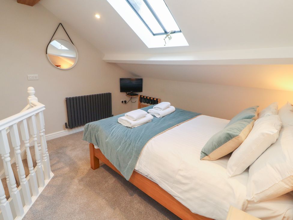 A bedroom with a bed and television at Wren's Nest Thornthwaite near Braithwaite