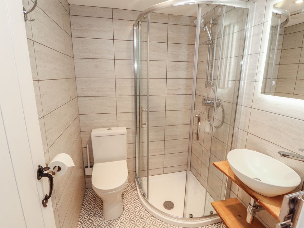 A bathroom with a shower and sink at Wren's Nest in Thornthwaite near Braithwaite