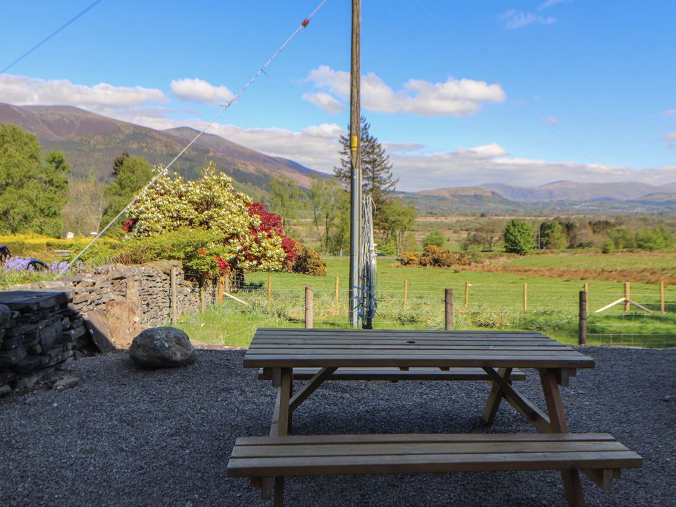 A picnic table with a view of mountains and greenery at Wren's Nest in Thornthwaite near Braithwaite