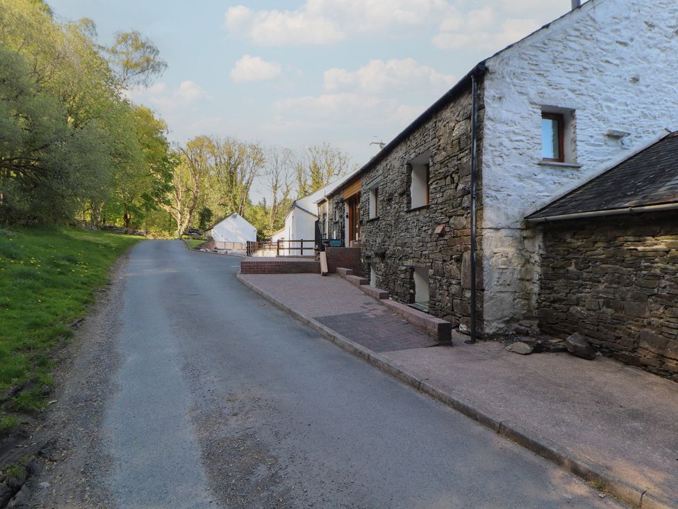 A roadside view of a stone house and garden at Wren's Nest Thornthwaite near Braithwaite
