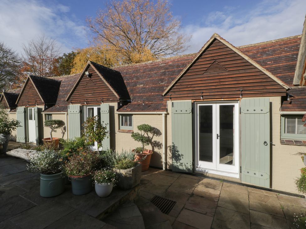 Exterior view of cottages with plants and doors at Cottage - 1 bedroom Broadway