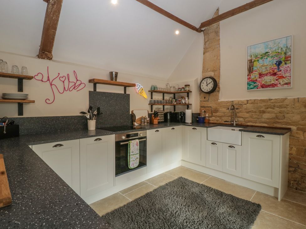 A kitchen with cabinets and shelves at Cottage - 1 bedroom in Broadway