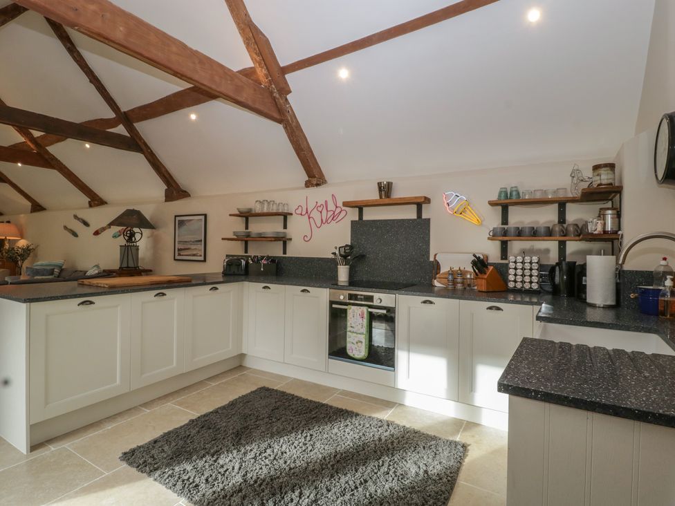 A kitchen with cabinets and countertop at Cottage - 1 bedroom in Broadway