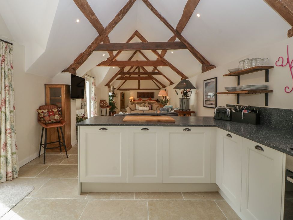 A kitchen with a kitchen island and sofa at Cottage - 1 bedroom Broadway