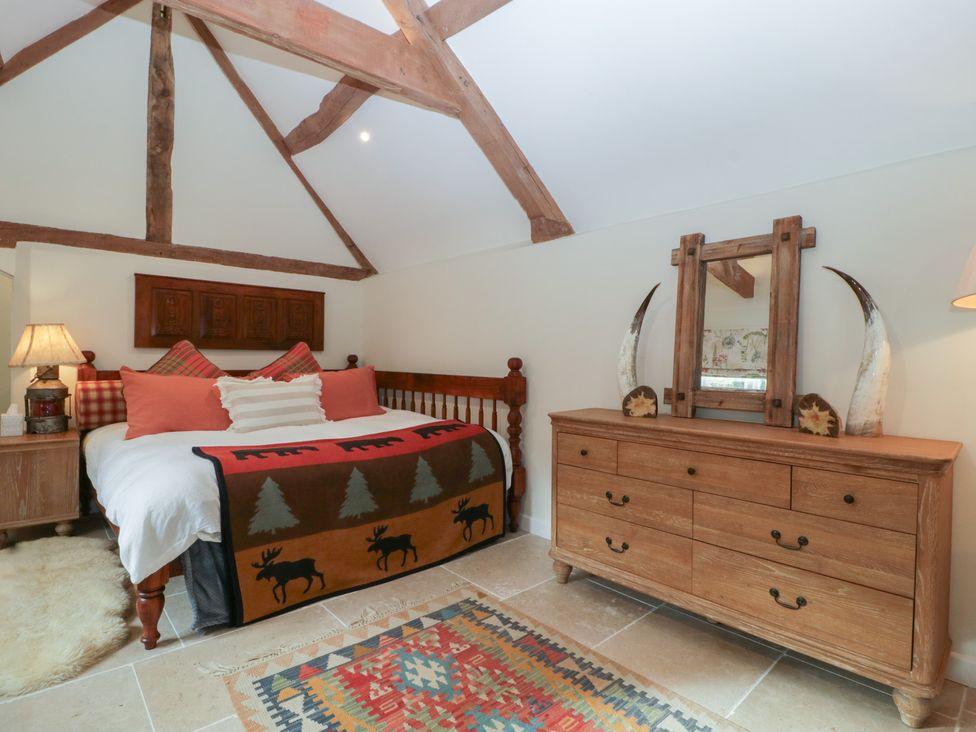 A bedroom with a bed and a dresser at Cottage - 1 bedroom Broadway