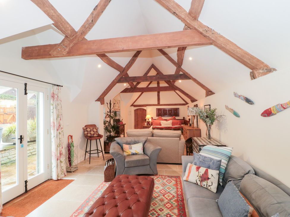 A living room with a sofa and armchair at Garden Cottage in Saintbury near Broadway