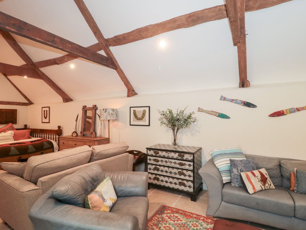 A living room with a sofa and coffee table at Garden Cottage in Saintbury near Broadway