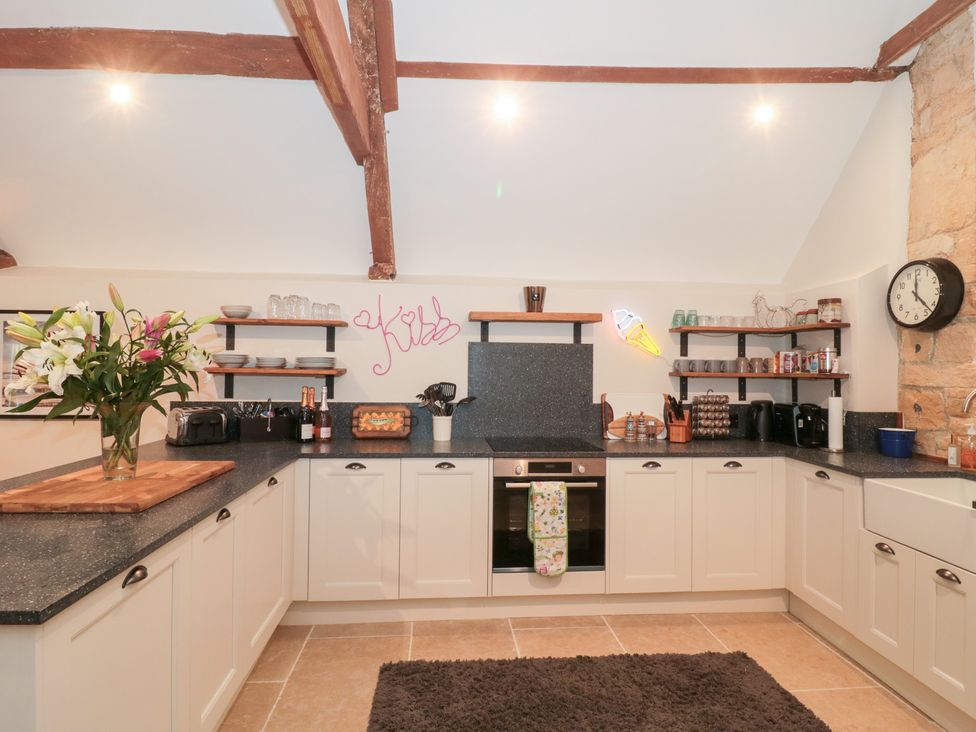 A kitchen with cabinets and countertop at Garden Cottage in Saintbury near Broadway