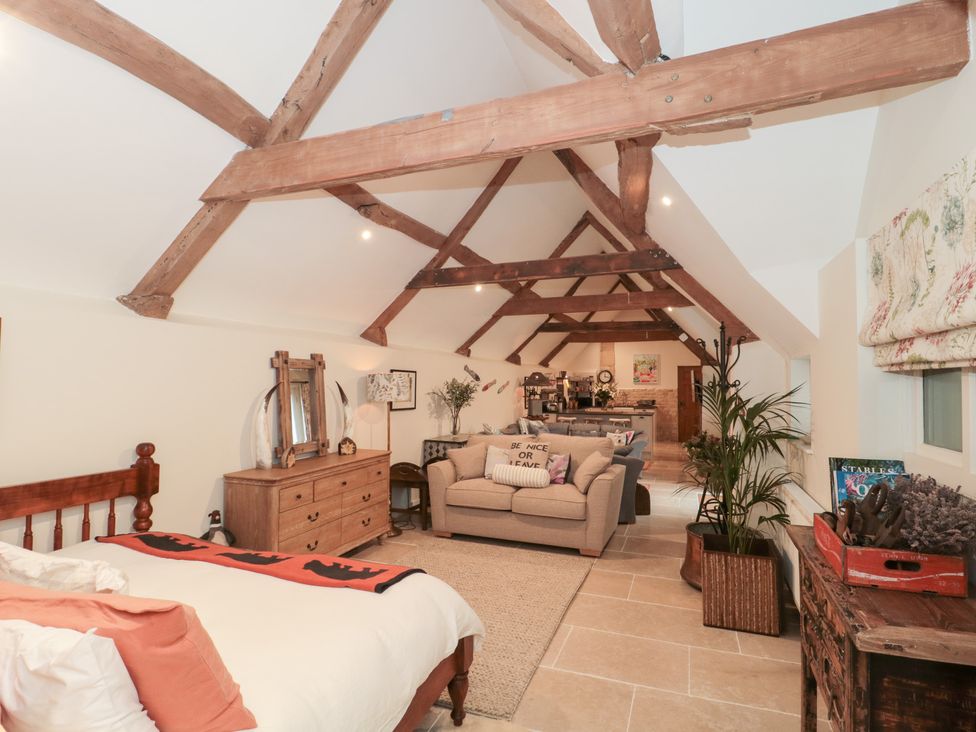 A living room with a sofa and dining area at Garden Cottage in Saintbury near Broadway
