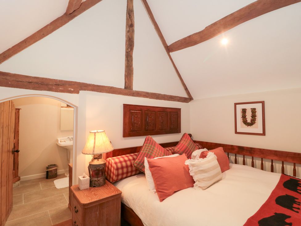 A bedroom with a bed and decorative pillows at Garden Cottage in Saintbury near Broadway