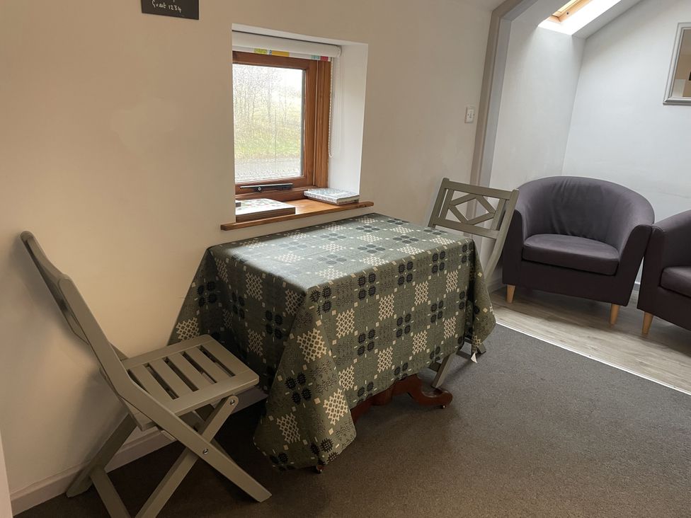 A dining area with a table and two chairs at Ty Hir at Blaenbrynich Farm Libanus near Sennybridge