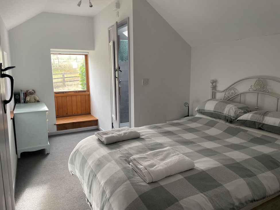 A bedroom with a bed and window at Ty Hir at Blaenbrynich Farm Libanus near Sennybridge