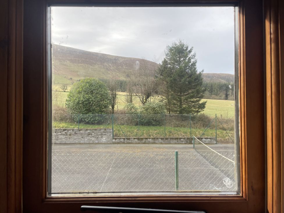 A view of mountains and trees from a window at Ty Hir at Blaenbrynich Farm Libanus near Sennybridge