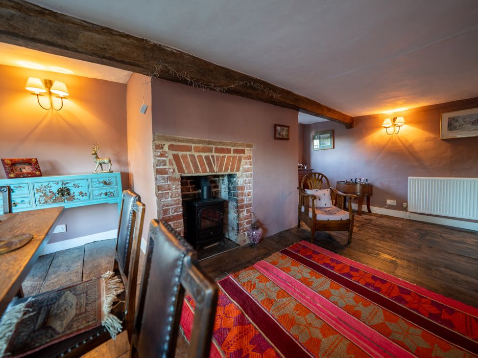 A living room with a fireplace and wooden furniture at 5 St. Michaels Close in Framlingham