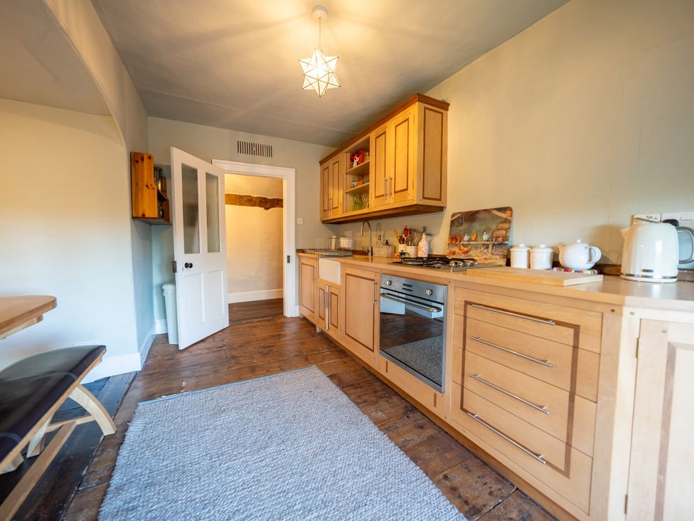 A kitchen with wooden cabinets and a dining table at 5 St. Michaels Close Framlingham