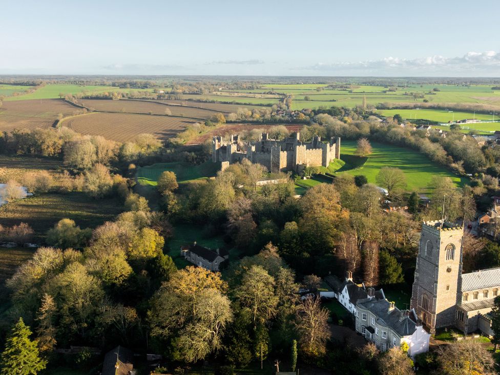 An aerial view of a castle and church surrounded by fields at 5 St. Michaels Close Framlingham