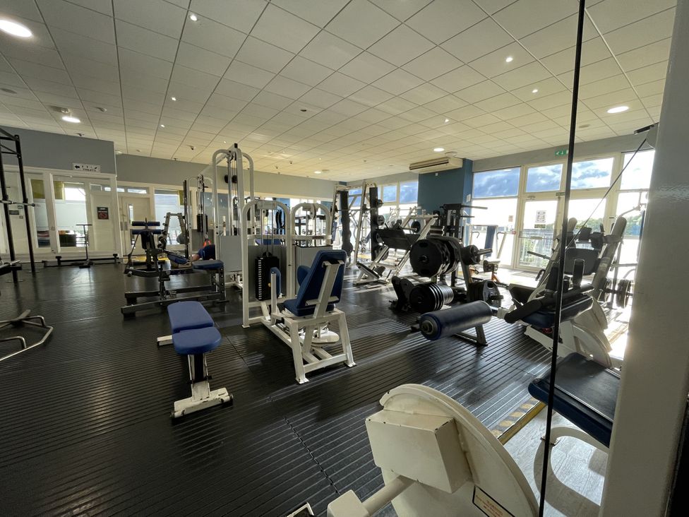 A gym with weight machines and exercise equipment at Satinwood White Cross near Newquay