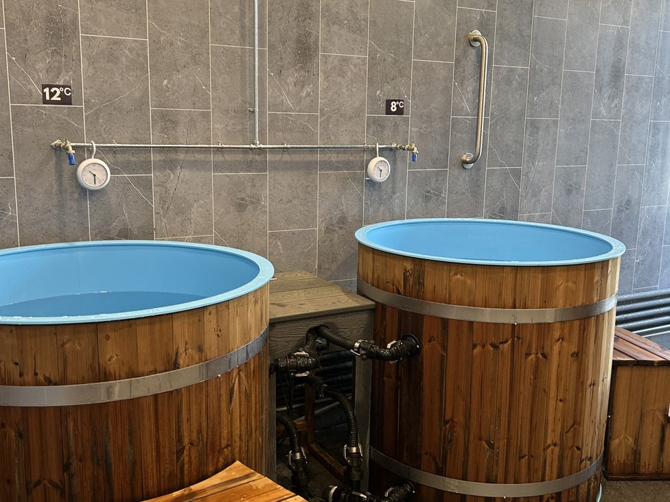 A spa area with wooden bathtubs and temperature gauges at Satinwood in White Cross near Newquay