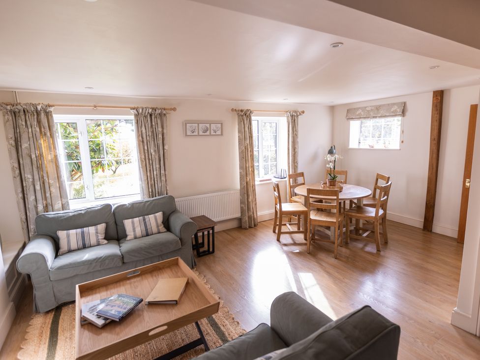 A living room with a sofa and dining table at Stable Cottage Lechlade-On-Thames