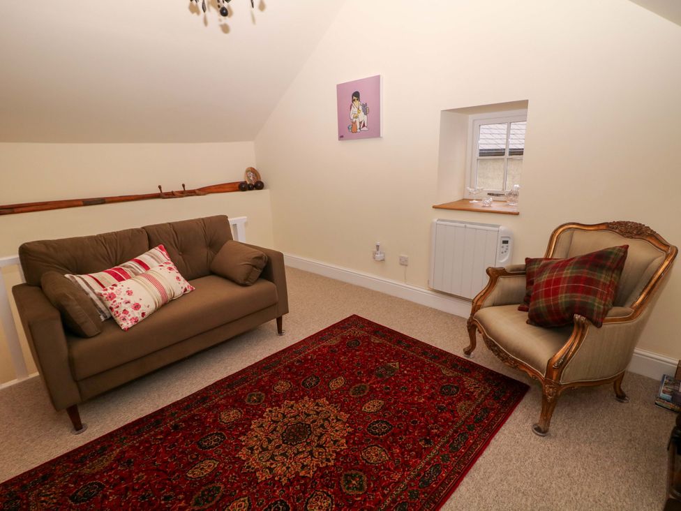 A snug with a sofa and armchair at Laneside Barn Calver